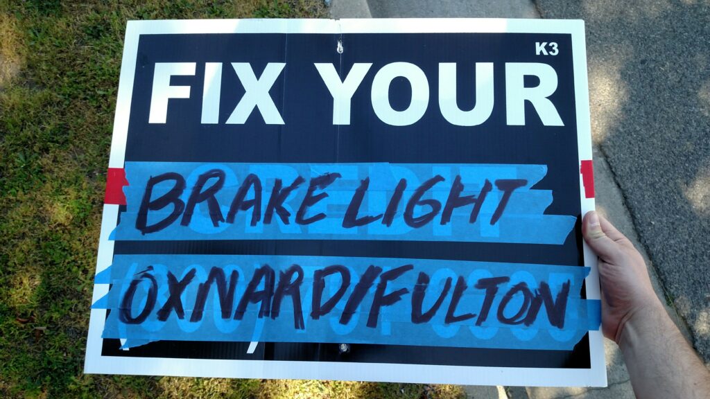 Sign reading "Fix Your Brake Light Oxnard / Fulton"